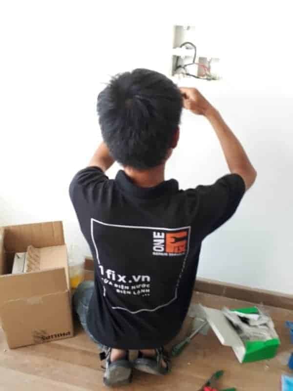 Thợ điện đang kiểm tra và sửa chữa ổ cắm điện bị lỏng tại nhà.