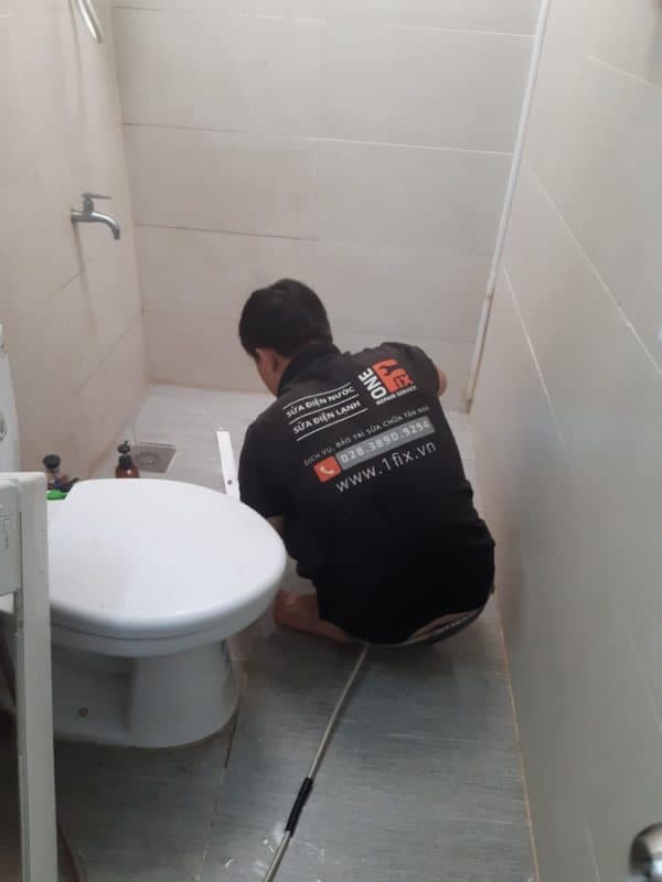 Thợ 1Fix đang sử dụng máy lò xo chuyên dụng để thông cống nghẹt tại một hộ gia đình ở Thủ Đức.