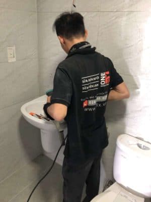 Thợ 1Fix đang kiểm tra và sửa chữa hệ thống vòi nước lavabo bị rò rỉ.