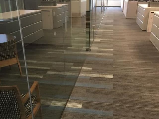 Kỹ thuật viên 1Fix đang sử dụng máy móc hiện đại để làm sạch sâu thảm văn phòng, đảm bảo không gian chuyên nghiệp.