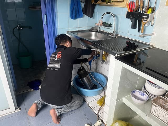 Thợ 1Fix đang thực hiện các bước lắp đặt chậu rửa bát 1 hố một cách chuyên nghiệp và cẩn thận tại nhà khách hàng ở TPHCM.