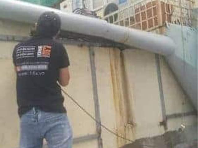 Thợ 1Fix kiểm tra tình trạng thực tế của máng xối bị rỉ sét và thủng tại một công trình ở TPHCM.
