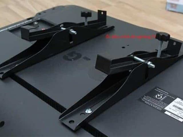 Thợ chuyên nghiệp đang hoàn tất các bước cuối cùng trong việc lắp đặt giá treo tivi, đảm bảo sự cân bằng và chắc chắn.