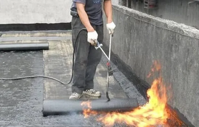 Thợ 1Fix dùng đèn khò thi công màng chống thấm bitum trên sân thượng